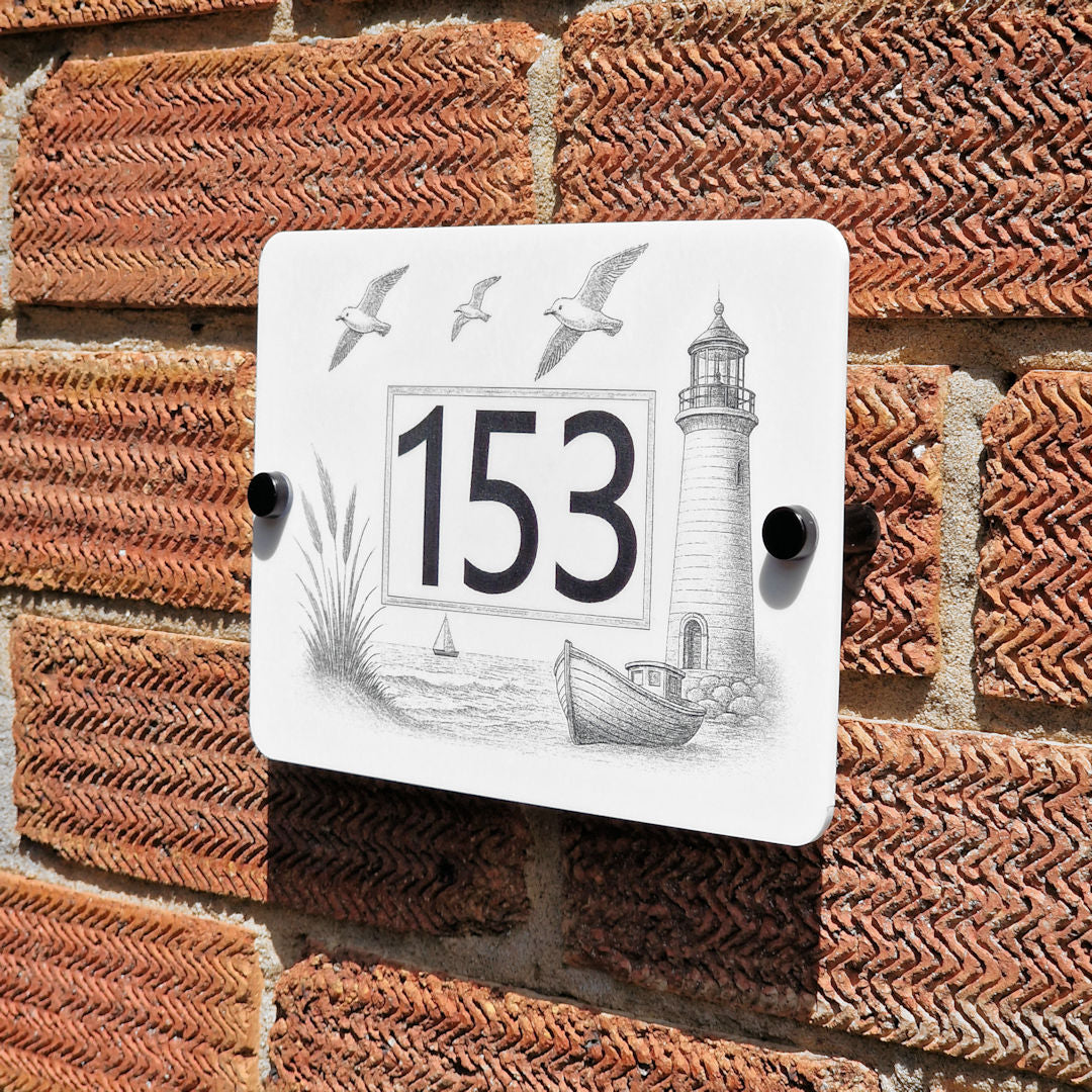 Decorative house number sign with lighthouse design on a brick wall