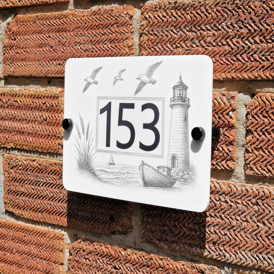 Decorative house number sign with lighthouse design on a brick wall